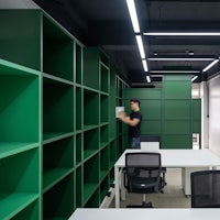 an office with green shelves and desks