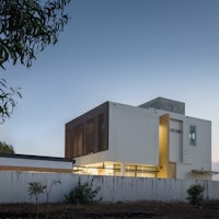 a modern house with white walls and a fence