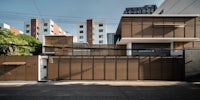 a modern house with wooden siding on the side of a street