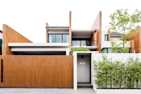 a modern house with a wooden fence and a wooden gate