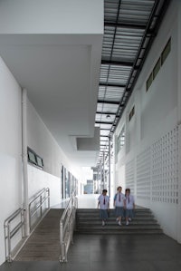 a group of children are walking down the stairs of a building