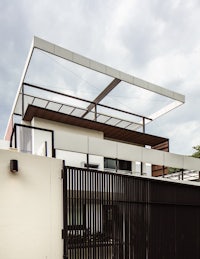 a modern house with a metal fence and a glass roof