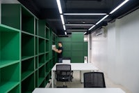 an office with green shelves and white desks