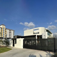 a modern house with a black fence and gate