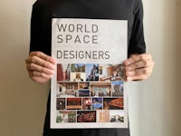 a man holding up a poster that says world space designers