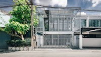 a house with a glass wall and wires on the side