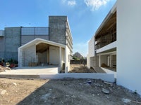 a house under construction with a white building in the background