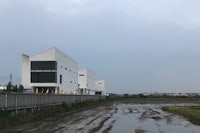 a white building next to a puddle of water