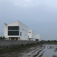 a white building next to a muddy area