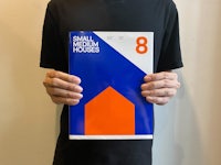 a man holding up a book with the title small medium houses