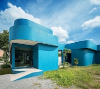 a blue building in the middle of a grassy field