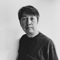 a black and white photo of a man leaning against a wall