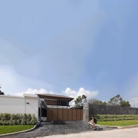 a man riding a bike in front of a modern house