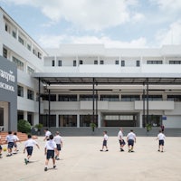 a group of children playing soccer in front of a building