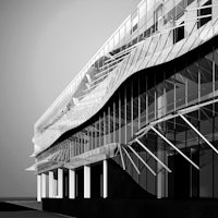 a black and white image of a building with a curved facade