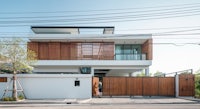 a modern house with wooden siding and a wooden gate