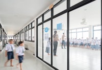 a group of children walking down a hallway in a school