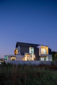 a modern house in the middle of a field at dusk