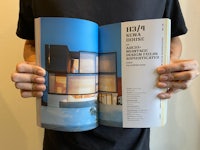 a man holding a book with a picture of a house