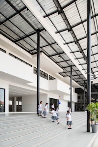 a group of children are walking down the stairs of a building