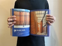 a man holding an open book with a picture of a building